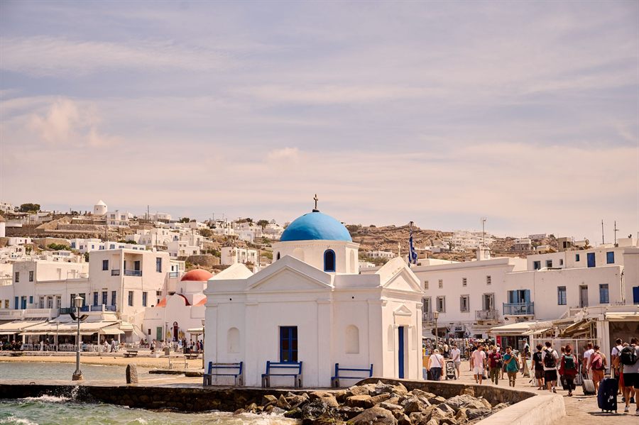 Blue-domed chapel and white houses on the Mykonos waterfront