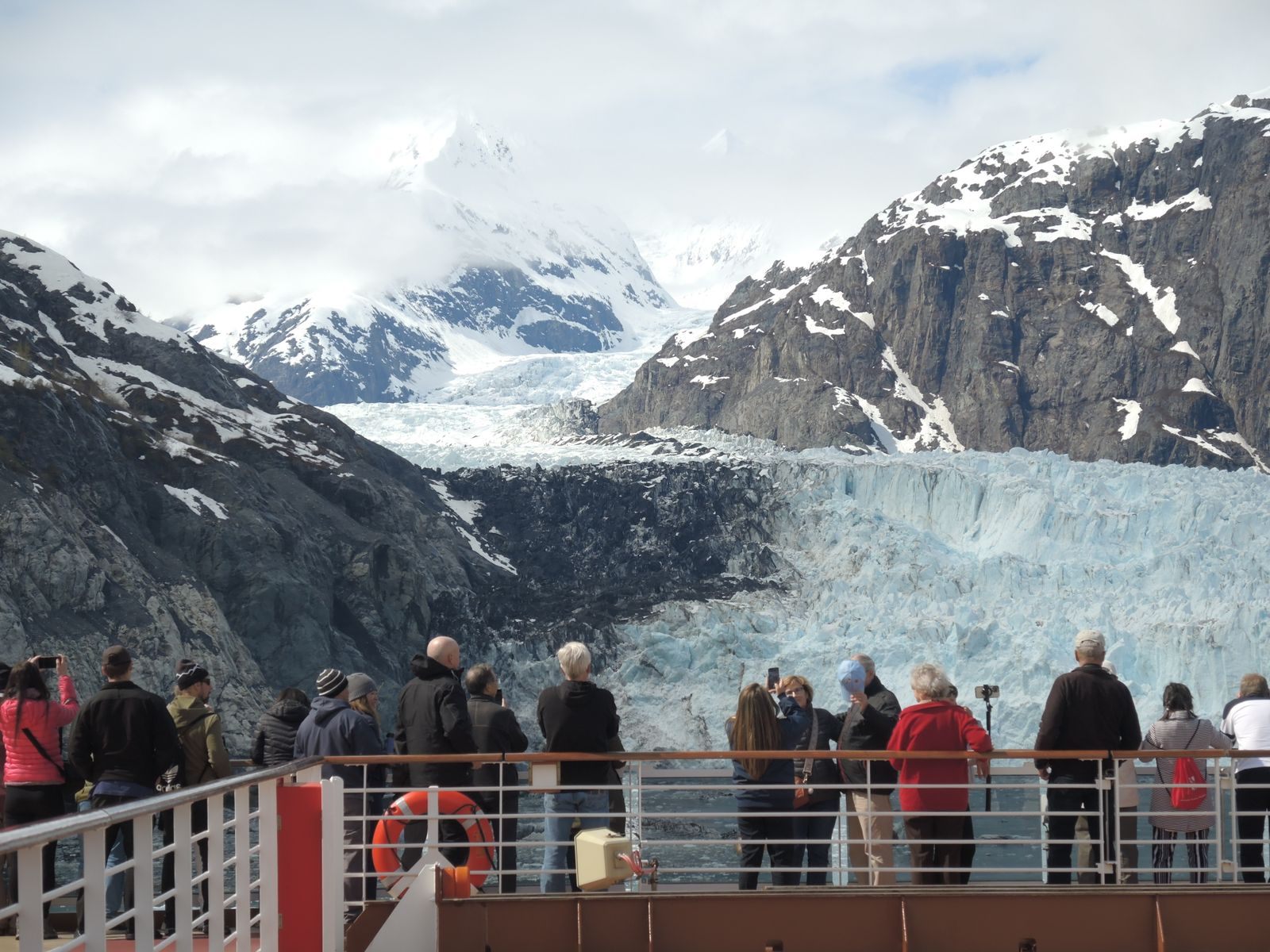 Guests on a ship&rsquo;s deck watching a glacier